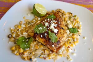 a picture of blackened snapper on top of a bed of creamed street corn